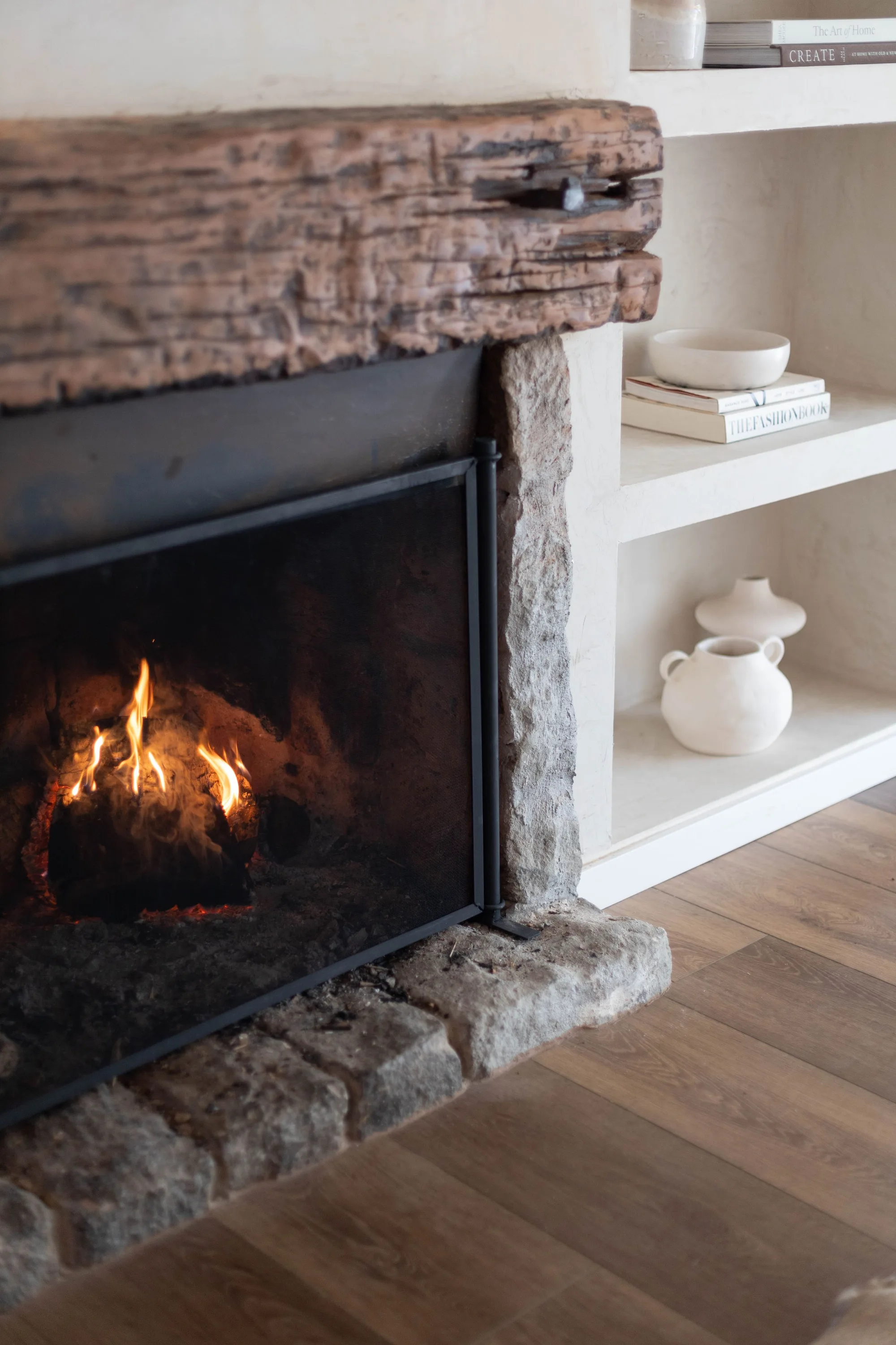 Fireplace detail with rustic mantel and white built-in shelving