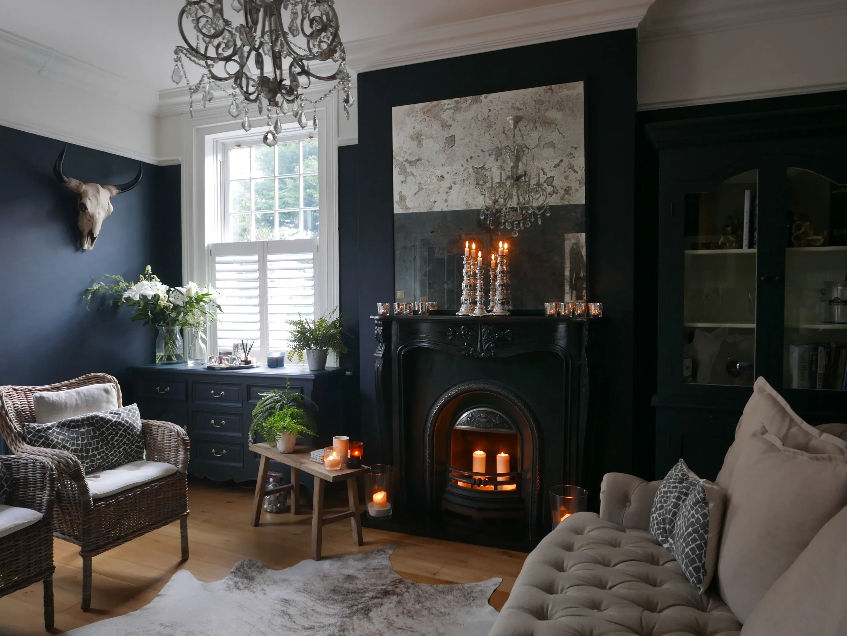 Living room with deep navy painted walls and a black fireplace